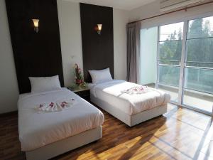 南邦南邦SR酒店的酒店客房设有两张床和窗户。