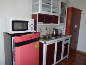 班佩罗勇公寓的一间小厨房,厨房内配有一台红色冰箱,上面配有微波炉