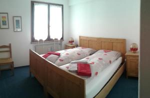 阿莱盖Appartamento Italia的一间卧室配有木制床、白色床单和红色枕头