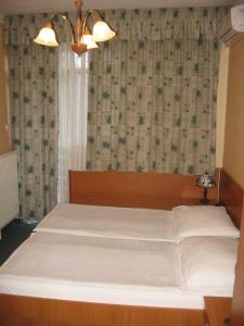 塔塔阿诺德酒店的卧室配有一张大白色床和窗户
