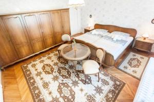 布达佩斯Haus in Budapest mit Garten的一间卧室配有一张床、一张桌子和一张地毯。