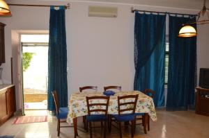 焦约萨马雷阿Giocasa的一间带桌椅和蓝色窗帘的用餐室