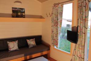 Montlaur勒阿穆德格内度假酒店的小房间配有沙发和窗户
