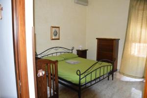 焦约萨马雷阿Giocasa的一间卧室配有一张带绿床罩的床