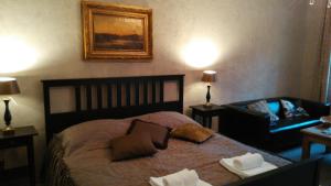 德辛Apartments Rose Garden的一间卧室配有一张床、一张沙发和一把椅子