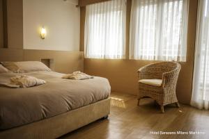 米兰马瑞提那Hotel Saraceno Resort的卧室配有床、椅子和窗户。