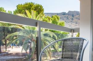 纳夫普利翁阿尼莫斯客房和公寓旅馆的棕榈树景阳台的椅子