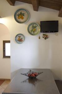 切法卢Terrazza delle mura的桌上一碗水果,墙上挂有盘子