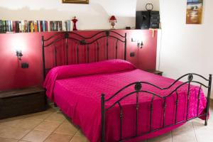 切法卢Terrazza delle mura的一间卧室配有红色的床和粉红色的床罩