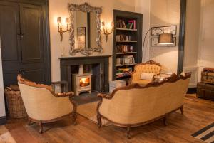 Saint Boswells巴克卢阿姆斯宾馆的客厅配有两把椅子和壁炉