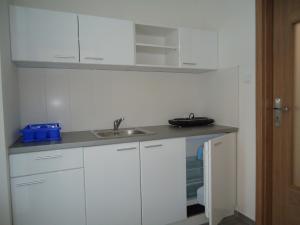 贝谢诺瓦Apartments Valentka的厨房配有白色橱柜和水槽
