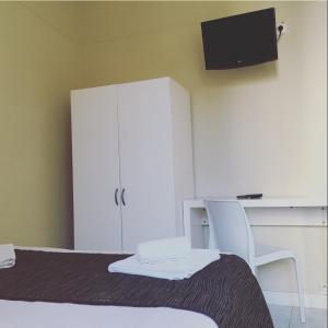 尼斯丹麦酒店的一间卧室配有一张床、一个橱柜和一张书桌