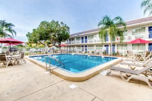 威尼斯Motel 6-Venice, FL的一个带椅子的游泳池和一间酒店