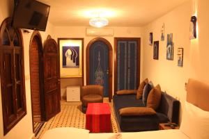 舍夫沙万舍夫沙万兹图那传统庭院住宅的客厅配有沙发、椅子和电视