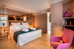 马德里巴塞罗帝国酒店的一间卧室配有一张床和一把椅子