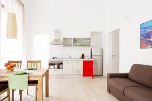 都灵托里诺住宿公寓的厨房以及带桌子和沙发的客厅。