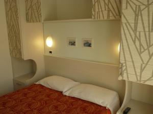 里米尼Hotel Haarlem的小房间设有床和窗户