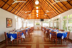 圣玛尔塔Sanha Plus Hotel的宴会厅配有蓝色的桌椅