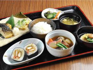 新泻新泻聚乐经济型酒店的装有碗食物和米饭的黑盘