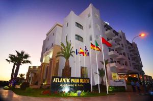 阿加迪尔大西洋棕榈滩公寓式酒店的前面有旗帜的建筑
