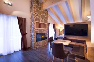 坎皮泰洛迪法萨马尔科拉酒店的一间带石头壁炉的客厅和一间卧室