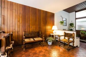马德普拉塔Hotel Urca的木墙、两把椅子和一张桌子