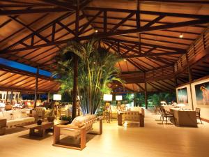 阿奎拉兹Dom Pedro Laguna Beach Resort & Golf的一间设有桌椅的餐厅,并种植了棕榈树