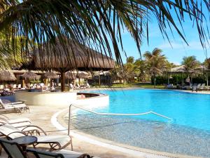 阿奎拉兹Dom Pedro Laguna Beach Resort & Golf的度假村的游泳池配有椅子和遮阳伞