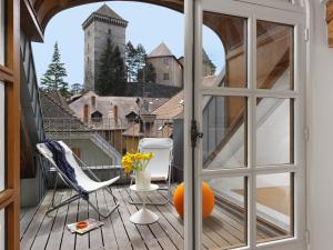 安锡Le Loft d'Annecy - Vision Luxe的通往带椅子和橙子的阳台的开放式门