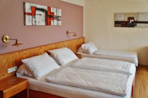 奥伊根多夫嘎斯霍夫祖尔斯特拉斯酒店的配有白色床单的酒店客房内的两张床