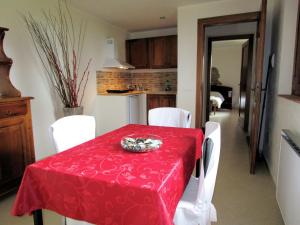 塞尔苏里格Belvilla by OYO Quattro Orcia的一间设有红色桌子和白色椅子的用餐室