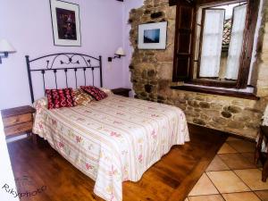 La Serna克拉梅尔旅舍的一间卧室设有一张床和石墙