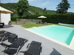 Hastière-par-delàCharming Holiday Home Along the Meuse的一个带椅子和遮阳伞的游泳池