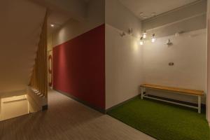 花莲市花莲北吉光轻旅青年旅馆的走廊上设有长凳和红色的墙壁