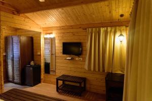 巴加Tranquility Cottage Resorts的小木屋配有电视和窗户