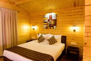巴加Tranquility Cottage Resorts的小木屋内一间卧室,配有一张床