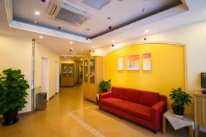 长春如家快捷酒店长春全安广场机场巴士站店的客厅设有红色的沙发和黄色的墙壁