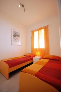 加利波利Baia Verde Apartments的一间卧室设有两张床和窗户。