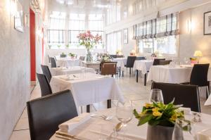勒皮安·梅多克伯内特普安特之家酒店的一间设有白色桌椅和鲜花的餐厅