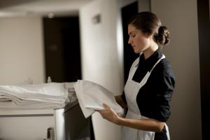 阿尔戈斯托利翁凯法利尼亚格兰德酒店的一位在厨房里拿着一张纸的妇女
