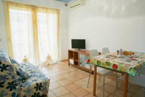 皮内托Poseidon Pineto Vacanza的客厅配有桌椅和电视。