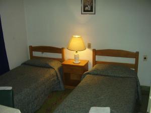 皮里亚波利斯Edificio Sagasti的两张床位于酒店客房,配有床头灯