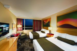 里士满River Rock Casino Hotel的酒店客房设有两张床和一台平面电视。