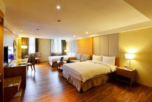 埔里阿波罗饭店的酒店客房,设有两张床和一张沙发