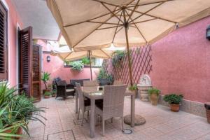 阿茨特雷扎B&B Epos Acitrezza的一个带桌子和遮阳伞的庭院