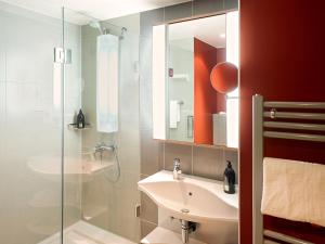 科隆科隆市阿德吉奥公寓式酒店的一间带水槽和玻璃淋浴的浴室