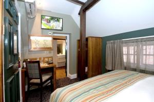 纽伯里威瑟斯本哈奇特酒店的一间卧室配有一张床和一张桌子及椅子
