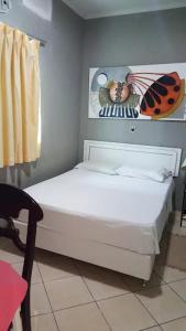 帕尔马斯Hotel Graciosa Palace的一间卧室,配有一张床铺,上面有一张女虫的照片