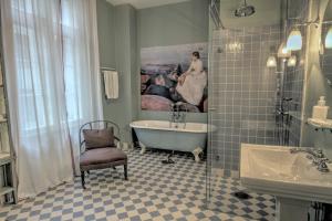 奥斯陆卡米拉斯胡斯酒店的带浴缸的浴室和墙上的绘画