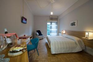 墨西拿西奥卢设计住宿加早餐旅馆的卧室配有1张床、1张桌子和1把椅子